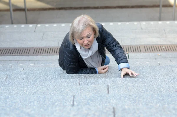 Indefensa mujer mayor cayendo por los escalones — Foto de Stock
