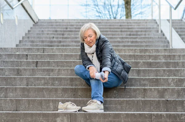 Çaresiz kadın kıdemli onun ayak Masaj