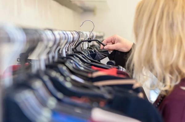 Female shopper searching through garments