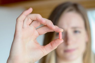 Tıbbi kapsül tutan genç sarışın kadın