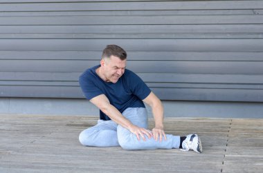Kas krampları ile sportif orta yaşlı adam