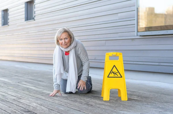 Seniorin krabbelt nach Ausrutscher auf Knien — Stockfoto