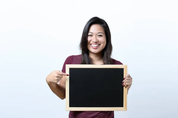 Mulher sorridente apontando para um quadro branco — Fotografia de Stock
