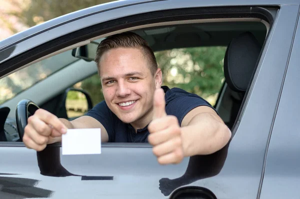 Счастливый молодой человек демонстрирует свои водительские права — стоковое фото
