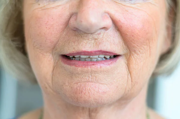 Lower face of a senior woman with lips ajar — Stock Photo, Image