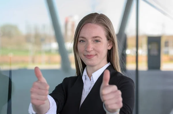 Blond kvinna håller tummen upp utanför — Stockfoto