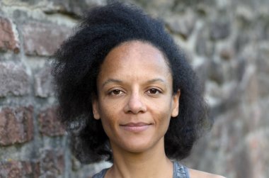 Tuğla duvara yakın gülümseyen güzel kadın