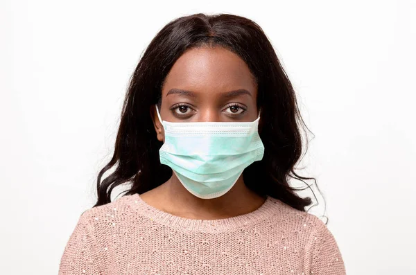 Cerrahi yüz maskesi giyen genç Afrika kadın