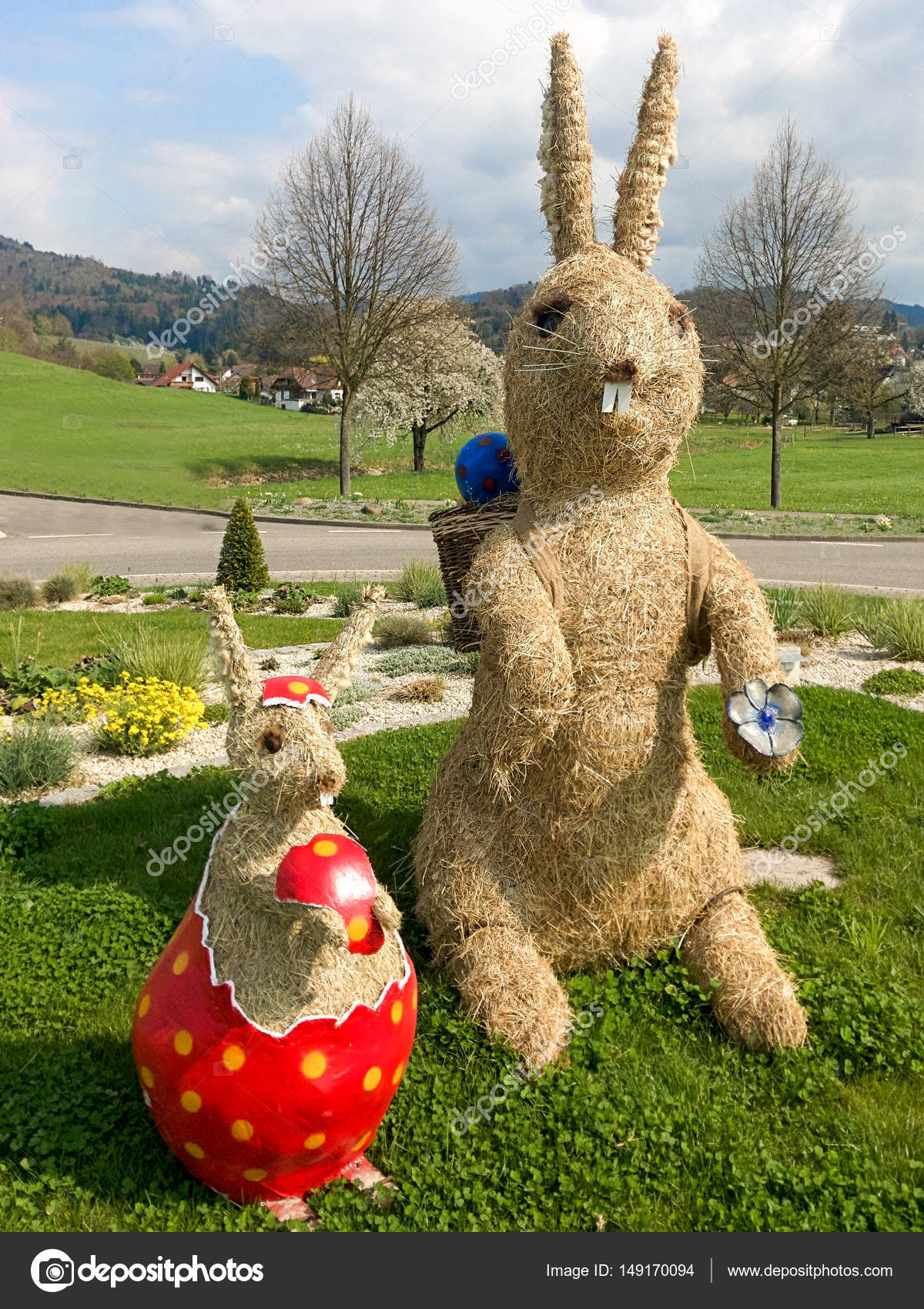 Zwei handgefertigte Stroh Osterhasen in einem Garten