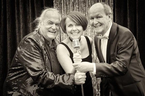 Three happy vocalists performing together on stage — Stock Photo, Image