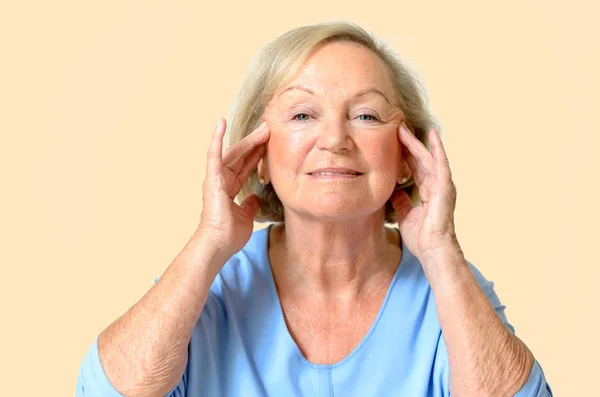 Starší žena ukazuje její tvář, efekt stárnutí — Stock fotografie