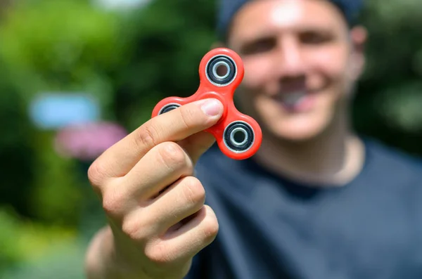 Młody człowiek bawi fidget spinner — Zdjęcie stockowe