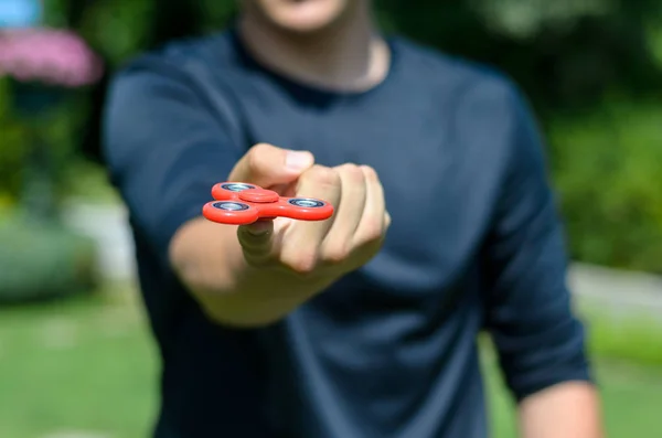 Młody człowiek bawi fidget spinner — Zdjęcie stockowe