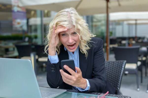 Empresaria reaccionando horrorizada a su móvil — Foto de Stock