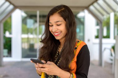 Hintli kadın bir metin mesajı okuyor smiling