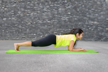 Yoga ile çalışan genç atletik Hintli kadın