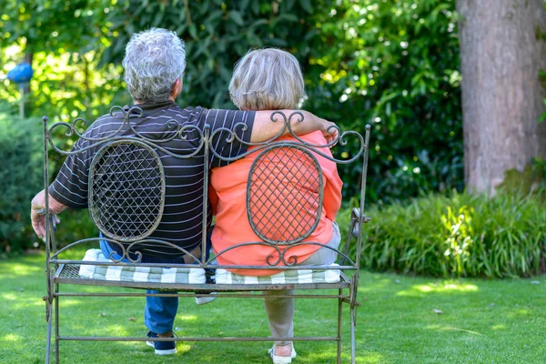 kıdemli bir çift bankta oturan  