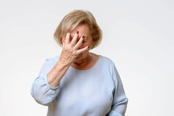 Senior woman covering her face with her hand — Stock Photo, Image