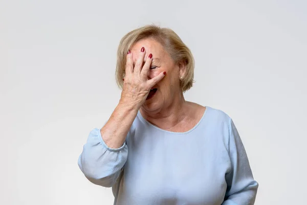 Senior woman covering her face with her hand — Stock Photo, Image