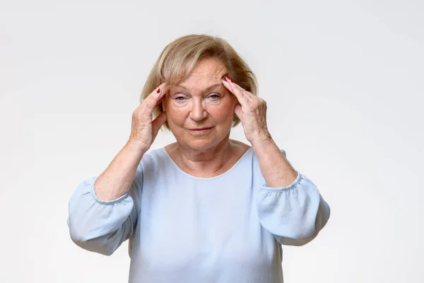Senior woman suffering from a severe headache — Stock Photo, Image