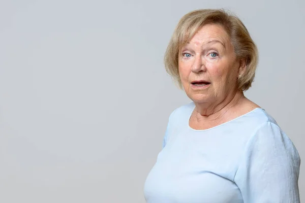 Verwunderte Seniorin blickt in die Kamera — Stockfoto