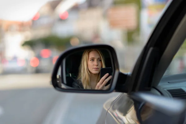 Junges blondes Mädchen im Außenspiegel des Autos — Stockfoto