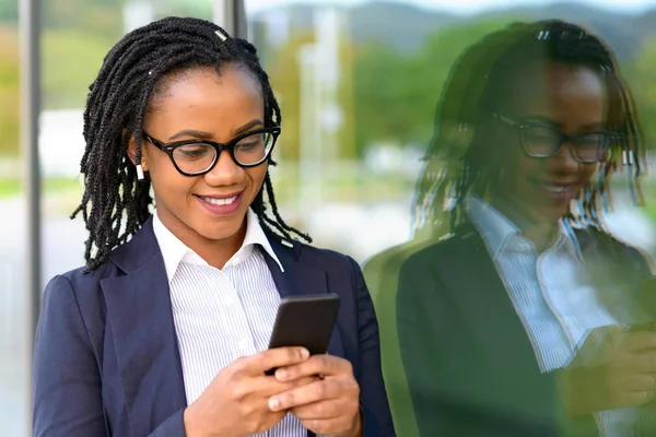 Lachende vrouw met behulp van mobiele telefoon — Stockfoto