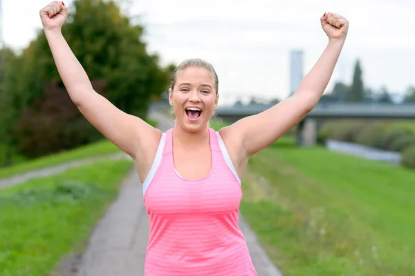 Young cheerful woman raising hands while running