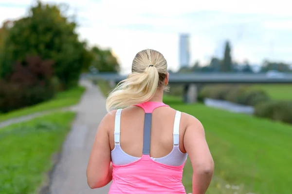 Blonde woman running along river — Stock Image Blonde woman running along river Stock Picture