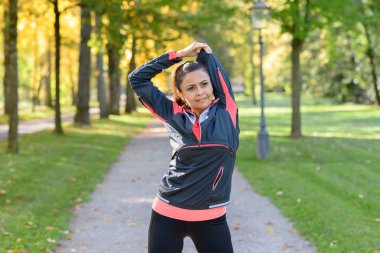 Kadın parkta güneşli günde germe