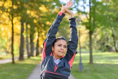 Kadın parkta güneşli günde germe
