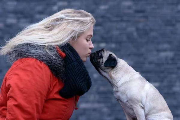 Side view of a Young woman with her pug