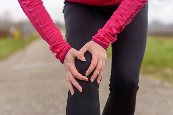 Jogger kobieta chwytając jej rannych kolana — Zdjęcie stockowe