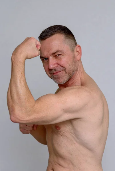 Hombre musculoso fuerte mostrando sus bíceps — Foto de Stock