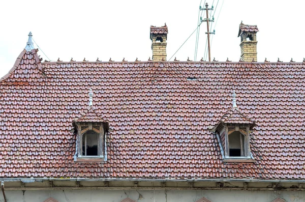 Two dormer windows in a red tiled roof