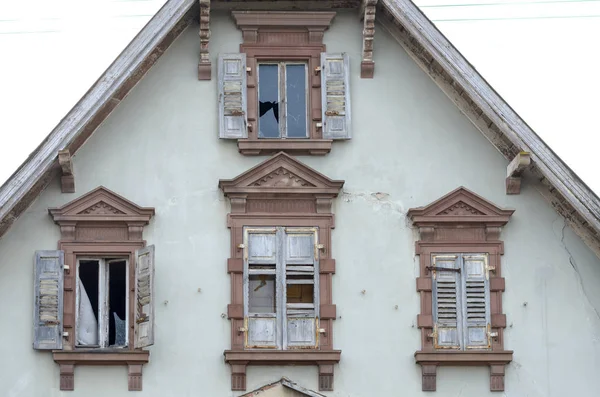 Fim gable e janelas de uma antiga casa abandonada — Fotografia de Stock