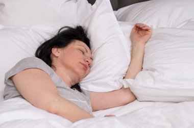 Young woman enjoying a good restful sleep clipart