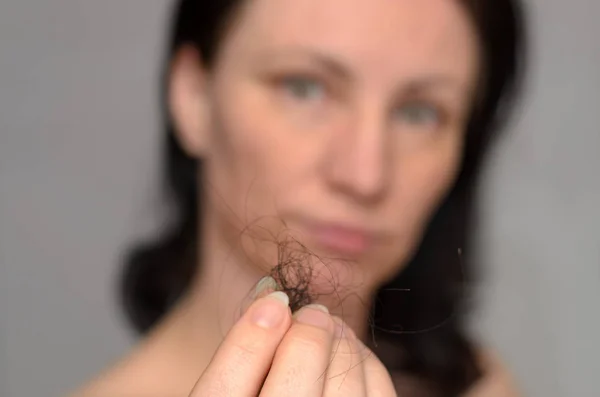Женщина, держащая клубок каштановых волос — стоковое фото