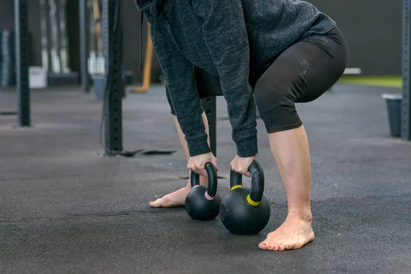 Fit woman working out with kettle weights