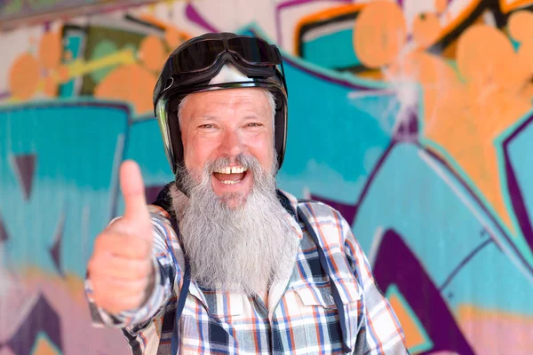 Cheerful bearded man with helmet giving thumb up