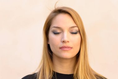 Rahatlatıcı, vurgulayarak veya baş shot portre yakından tarafsız studio arka plan üzerinde meditasyon sakin çekici sarışın kadın gözleri ile kapalı