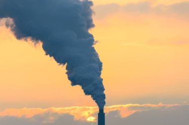 Endüstriyel bacadan duman fışkırıyor.