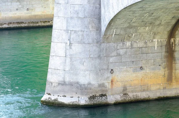 Pilastro di pietra su un sostegno di ponte su un fiume — Foto Stock