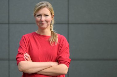 Gülen bir gülüşü olan kendine güvenen çekici bir kadın.