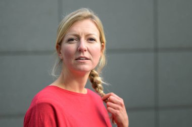 Çekici, orta yaşlı, saçları örgülü sarışın kadın.