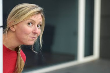 Köşeden gözetleyen komik görünüşlü bir kadın.