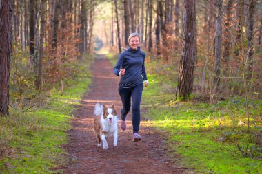 Healthy fit woman running with her dog