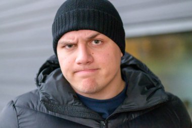 Kararlı şüpheci genç adam kameraya kaş çatıyor