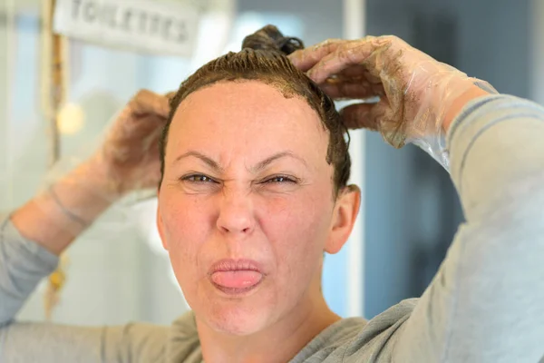 Donna Tirando Viso Sporgendo Lingua Mentre Applica Tintura Capelli Capelli — Foto Stock