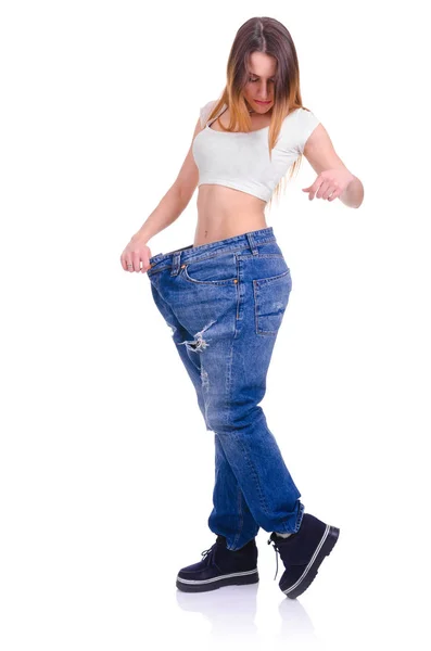 Chica joven en pantalones vaqueros azules de gran tamaño sobre un fondo blanco — Foto de Stock